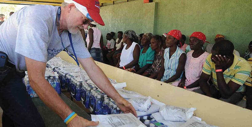 Aid worker distributing water to refugees.