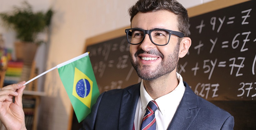 International teacher with a Brazilian flag teaching math to his students.