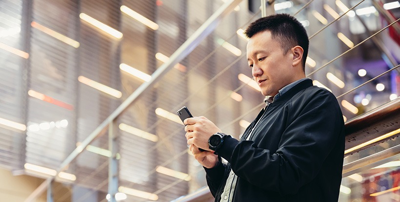 International worker checks incoming messages on his phone.