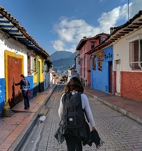 Volunteer backpacker walks down the colorful streets of Colombia.