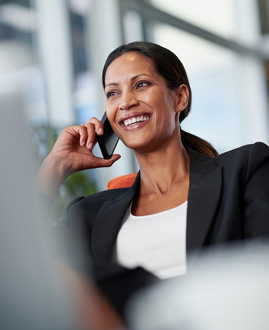 Smiling business woman renewing her policy over the phone.