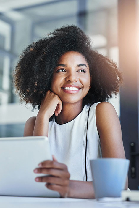 Employee at work smiles out window as she takes in some sun.