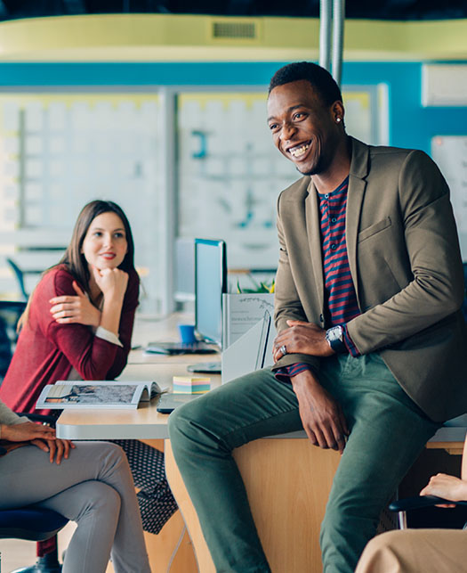 Businessmen and women engage in a lively conversation at their office.