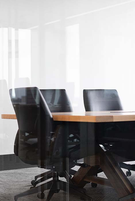 Modern conference room lies vacant behind glass doors.