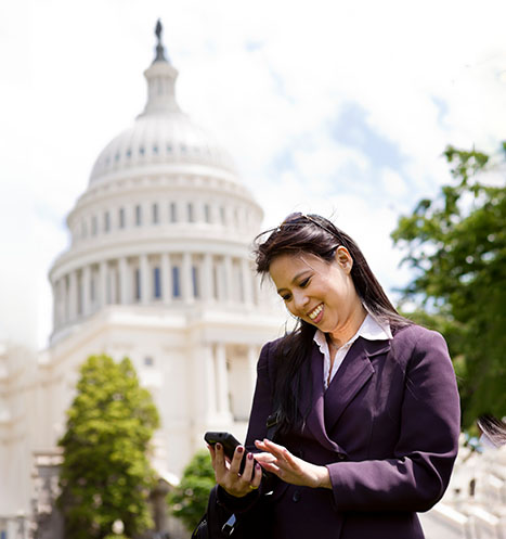 Federal contractor working on her phone by the US capitol.