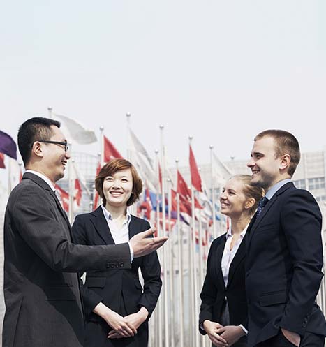 International diplomats discussion in front of country flags.