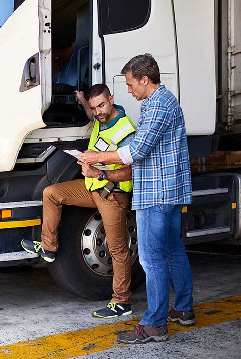 Contractor truck driver reviews work route with manager..