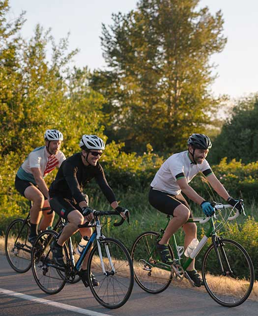 A group of cyclists in a friendly race down a scenic road.