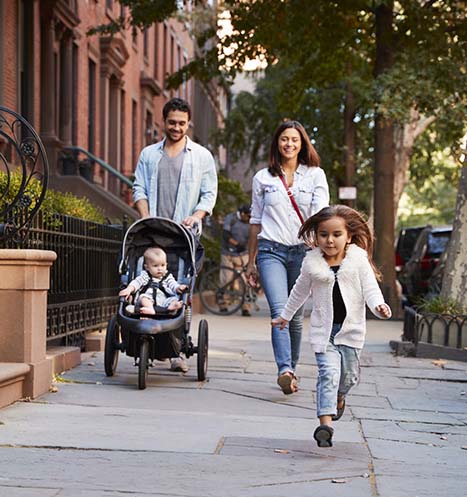 Happy family of four take an evening stroll around their neighborhood.