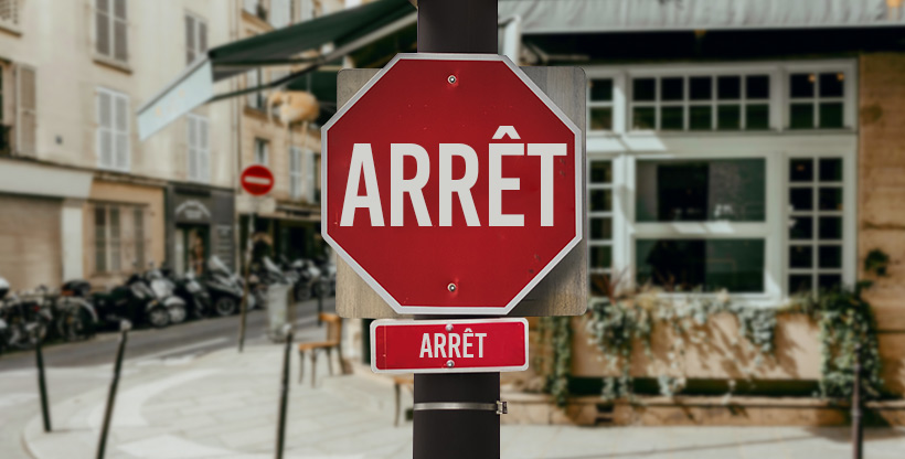 Traffic signs, like a stop sign in French, can help expats learn words in their target language.