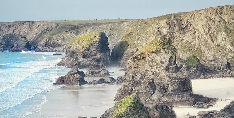 Giant rock outcroppings sit atop the beach in a small alcove called Bedruthan Steps.